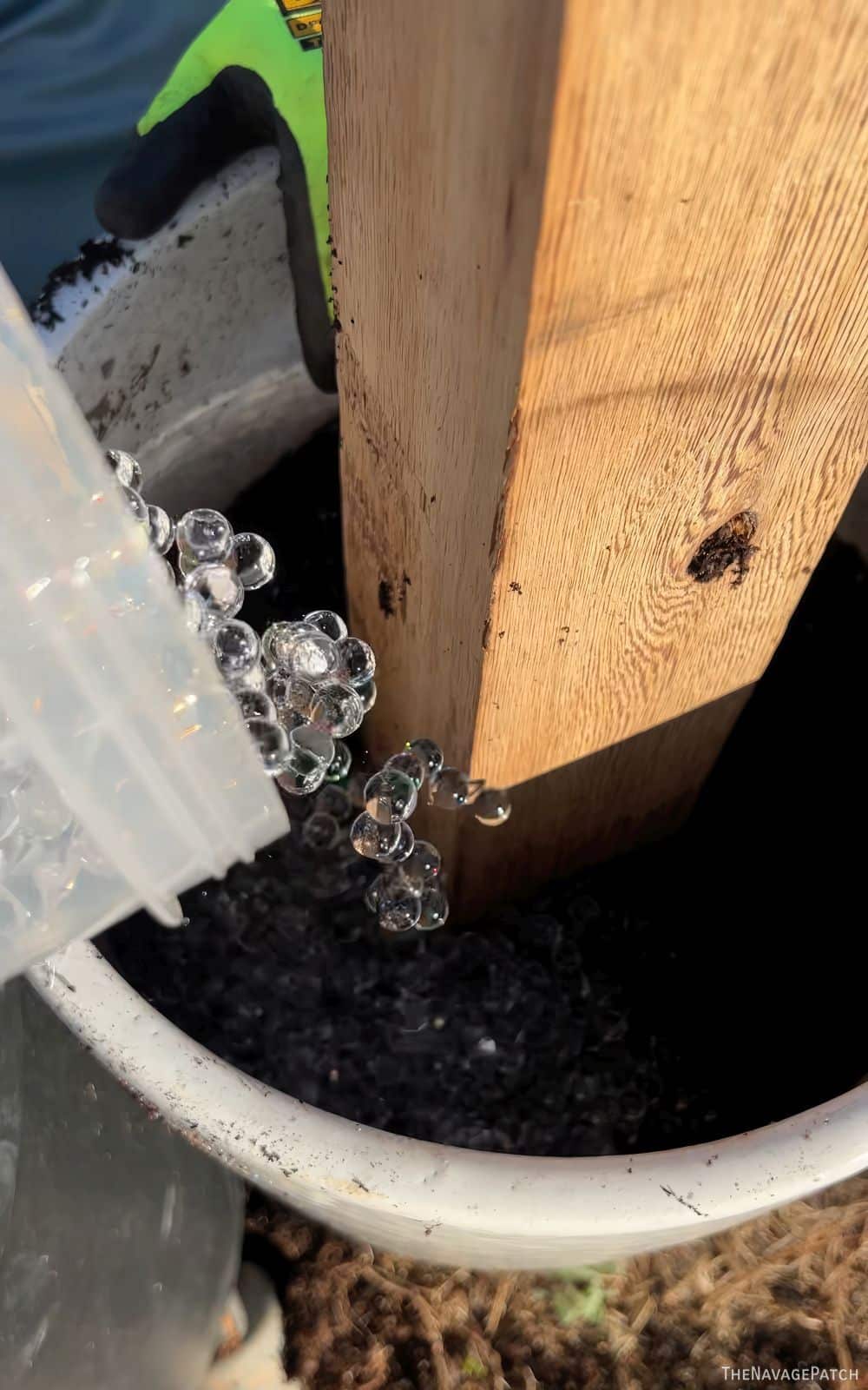 man putting water beads into a planter