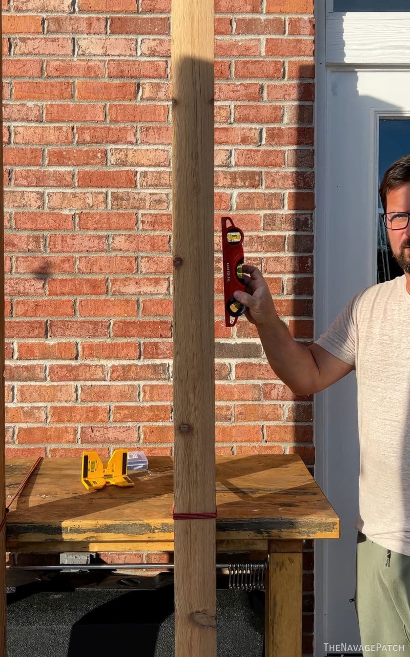 man levelling posts in concrete