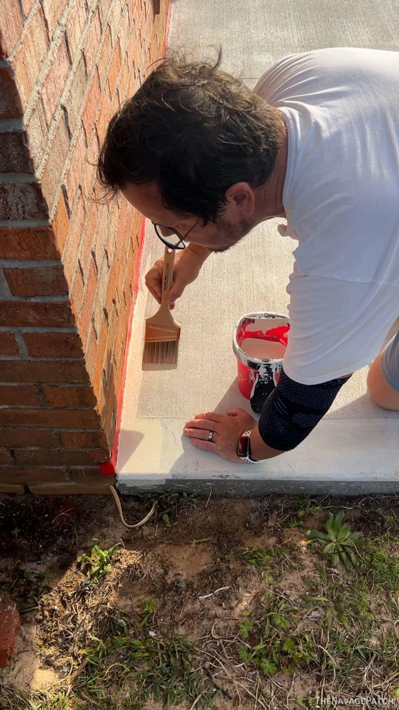 man staining a patio