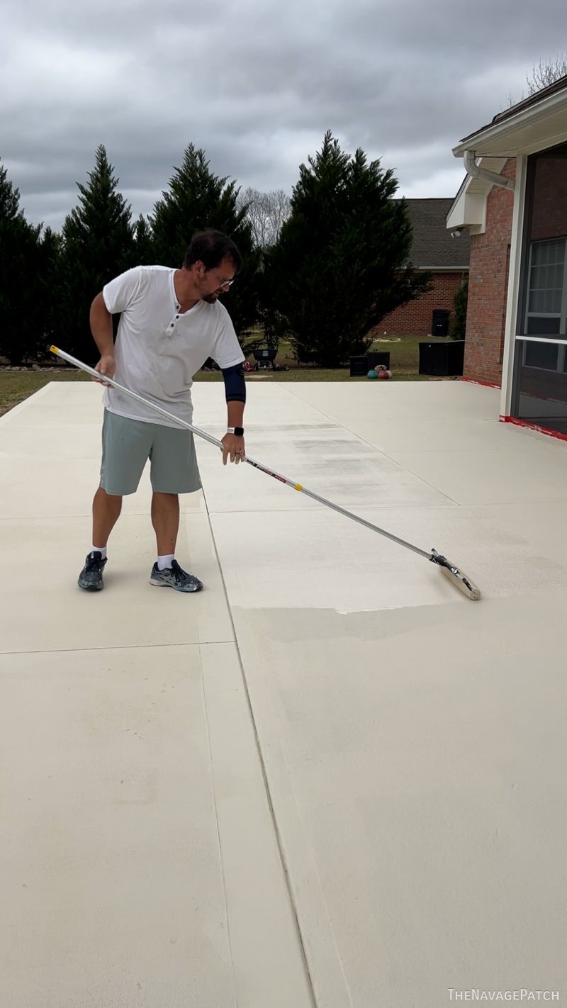 man staining a patio