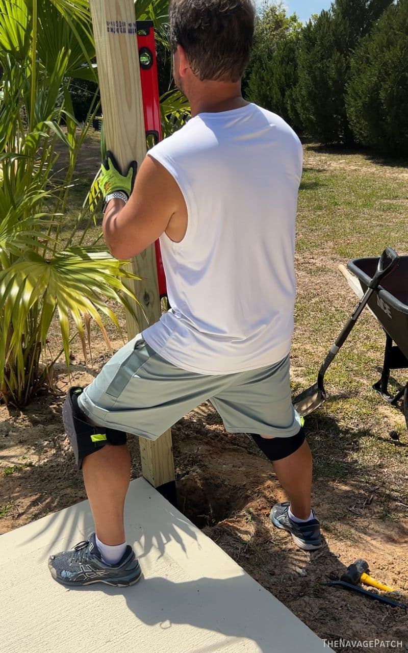 man plumbing a fence post