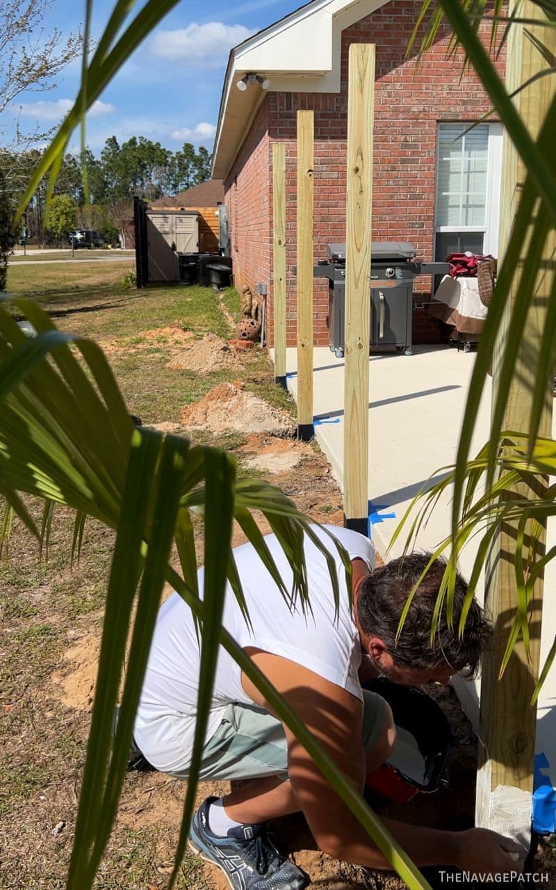 man priming fence posts