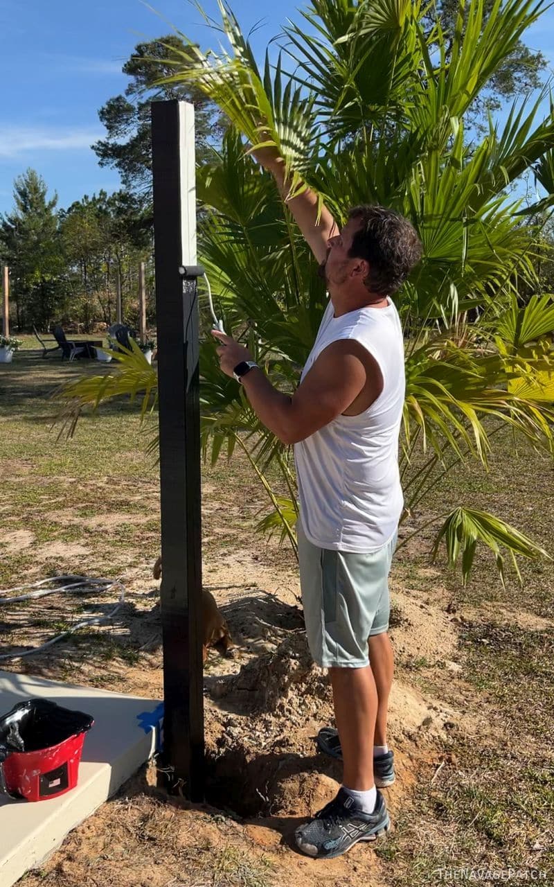 man painting fence posts