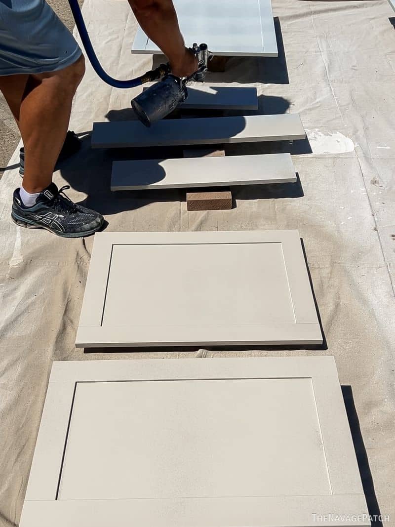 man painting cabinet doors