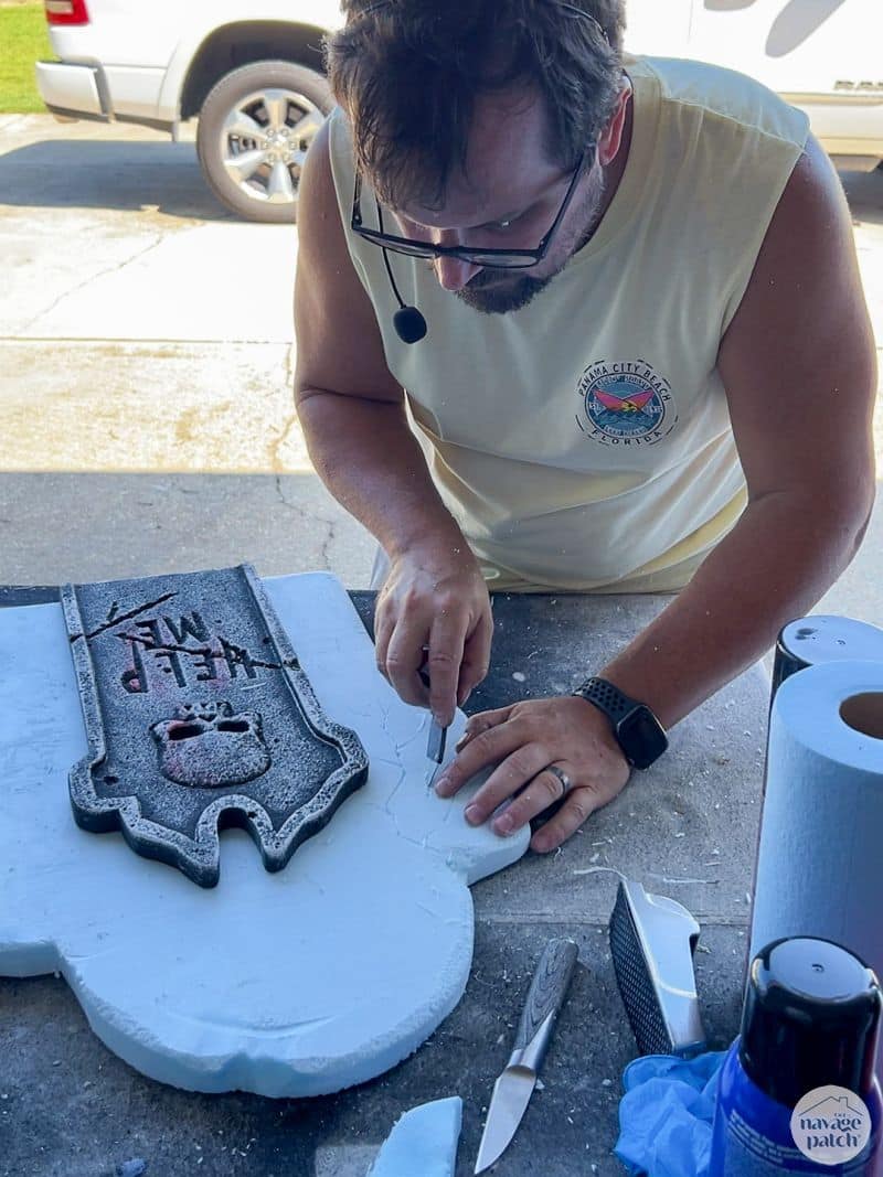 man making cracks in tombstone