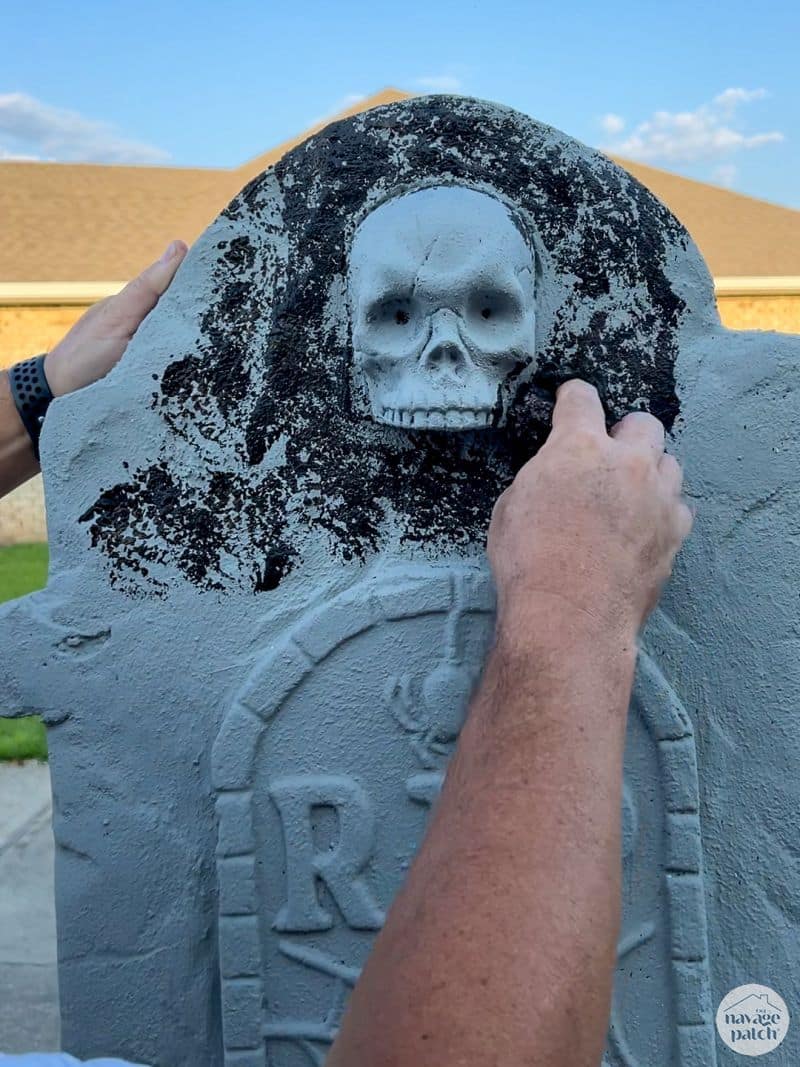 man painting tombstone