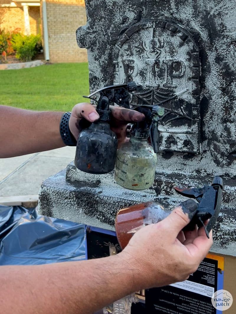 man painting tombstone