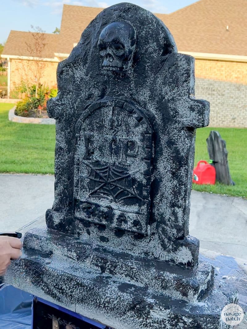 man painting tombstone