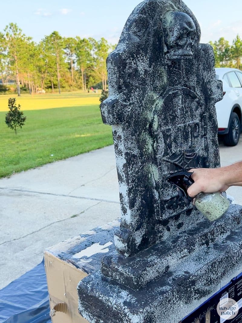 man painting tombstone