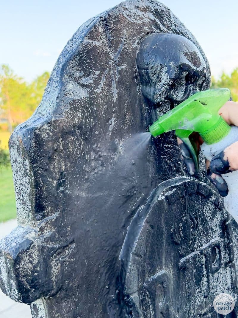 man painting tombstone