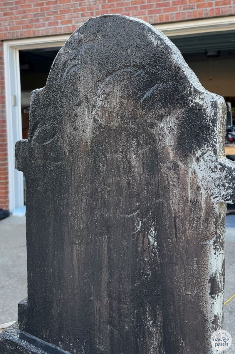 man painting tombstone