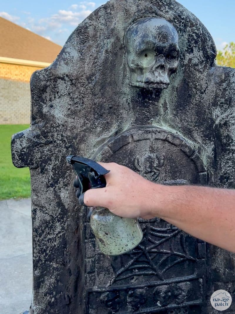 man painting tombstone