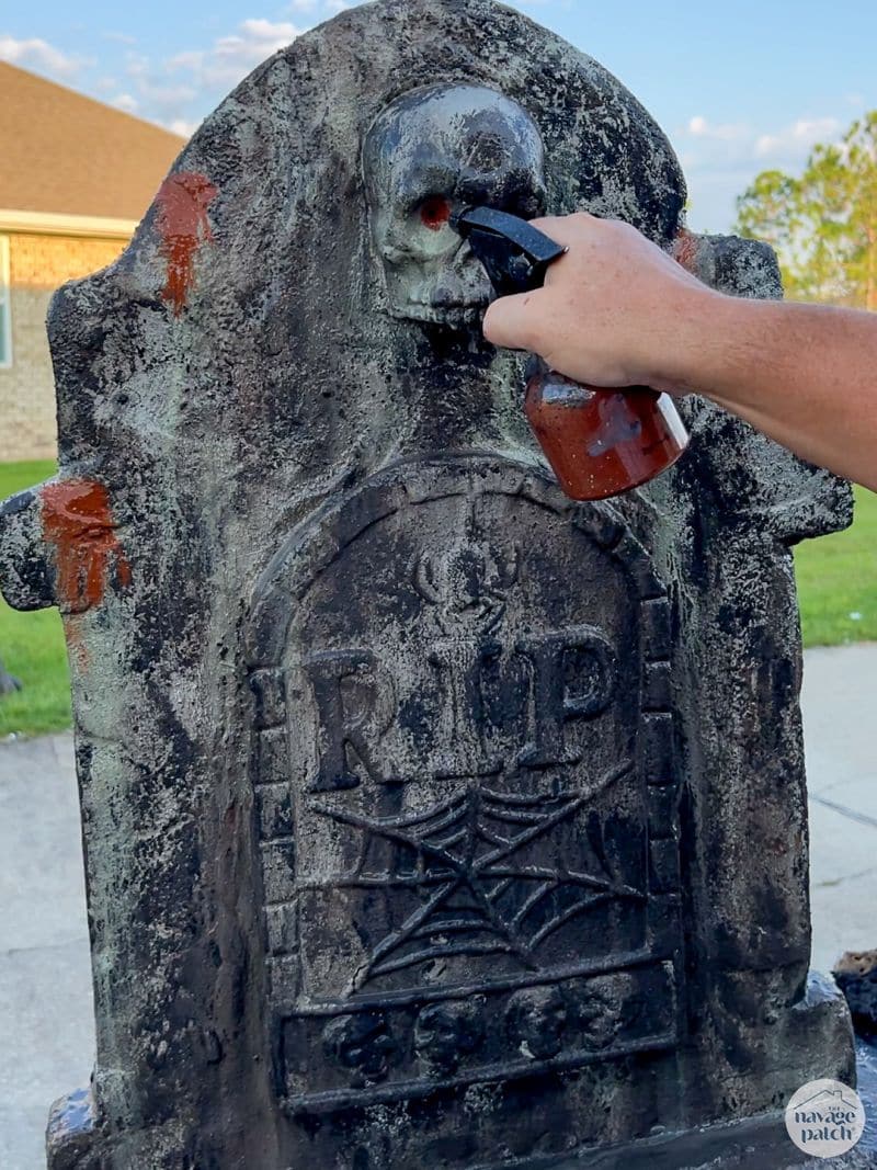 man painting tombstone