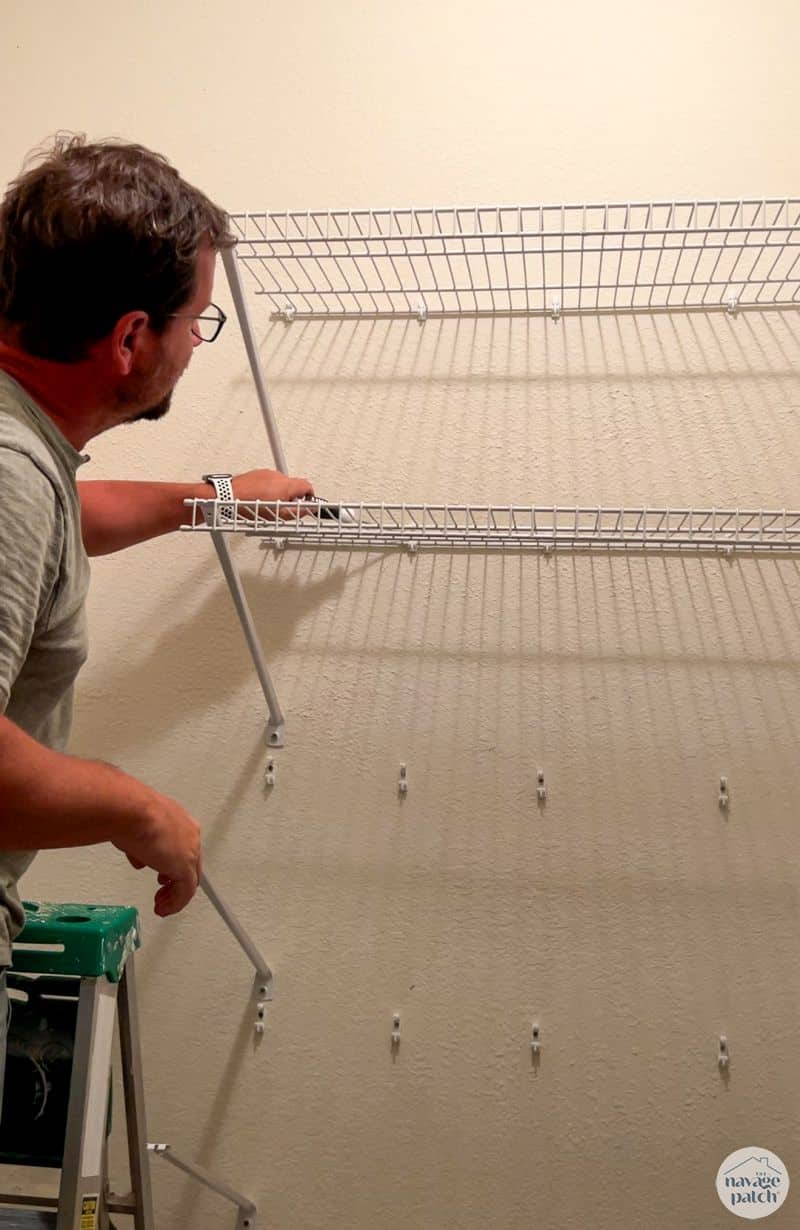 man taking apart wire closet shelves 