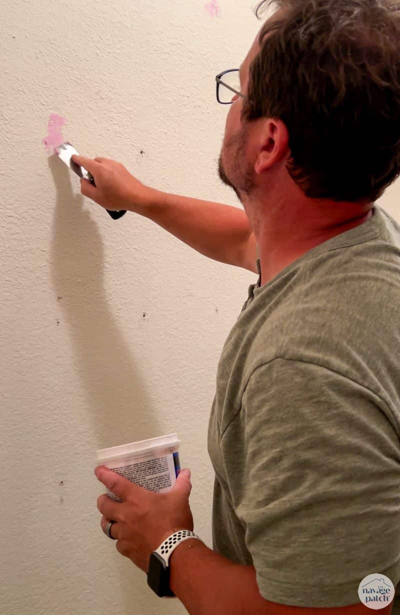 man spackling nail holes