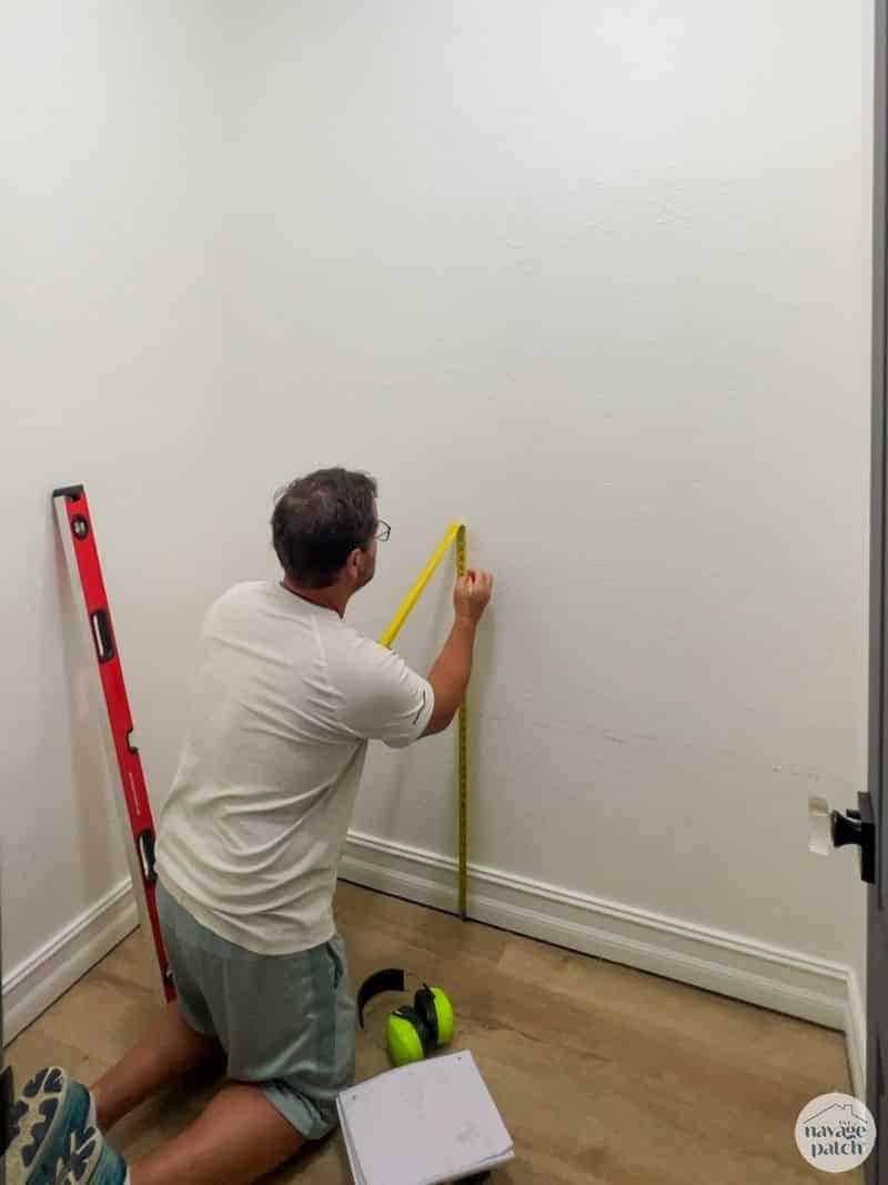 man marking a closet wall for closet shelves