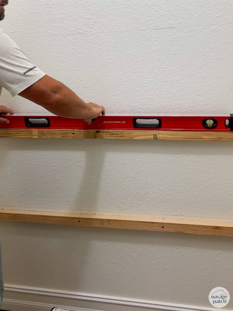 man installing shelf supports for closet shelves