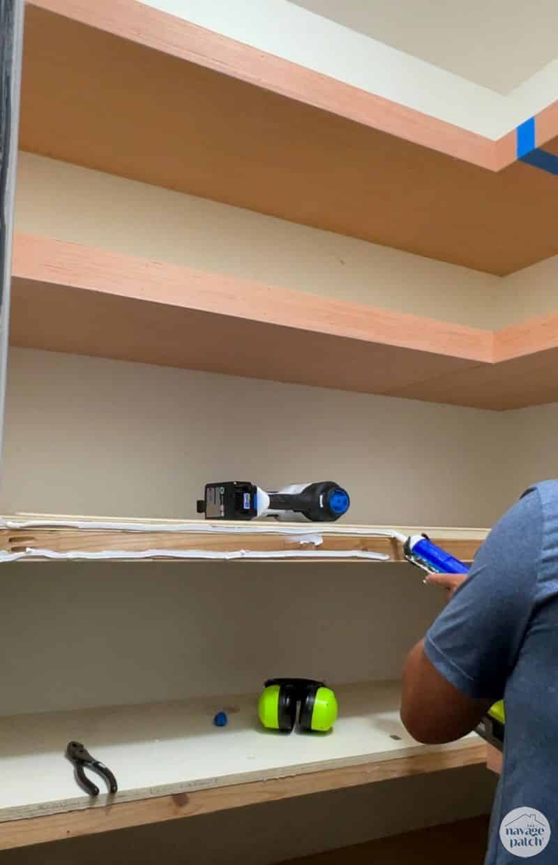 man adding trim to closet shelves