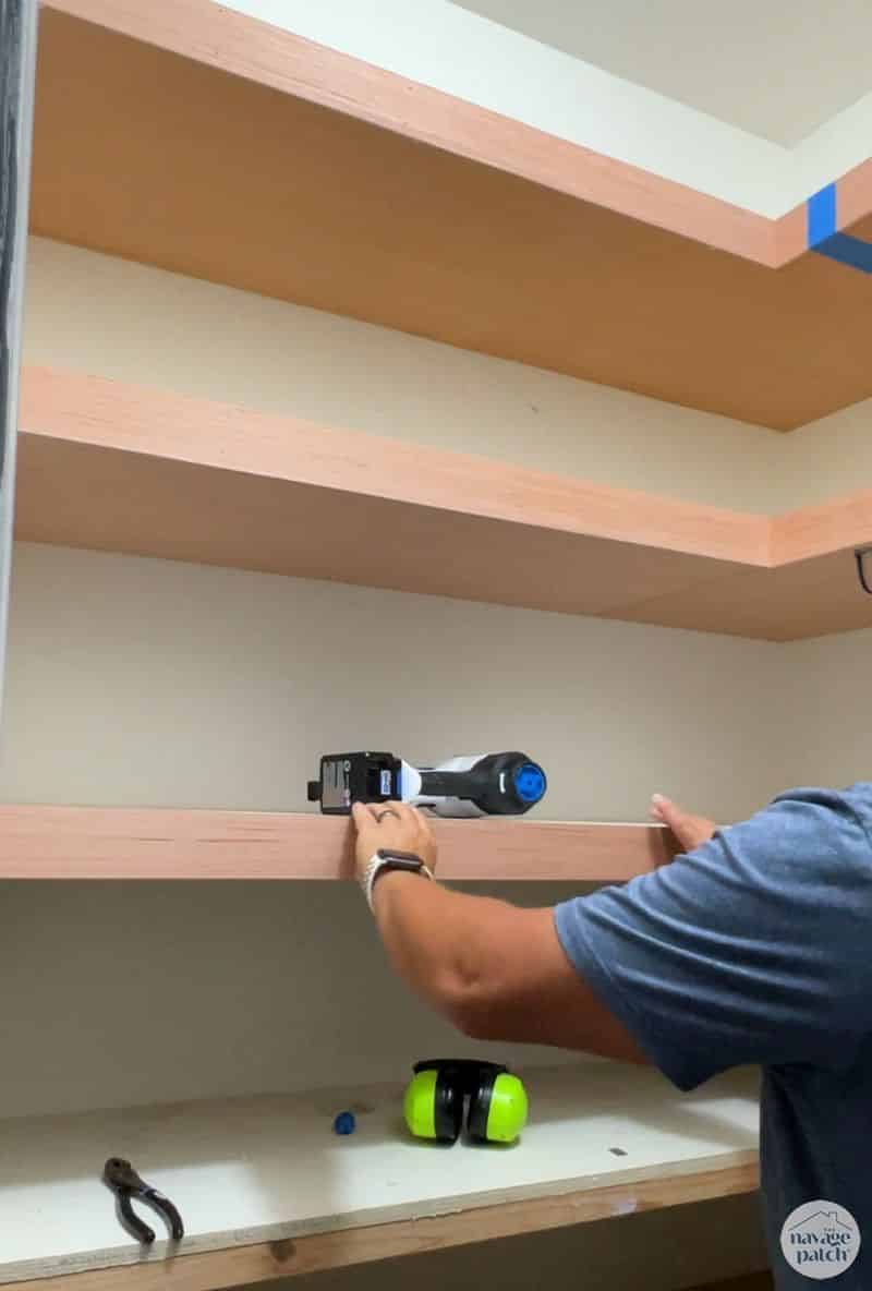 man adding trim to closet shelves