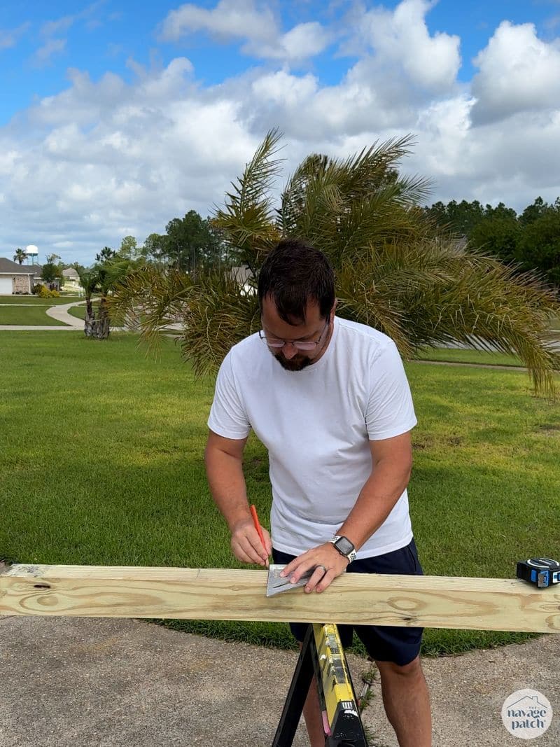 man cutting 4x4 post