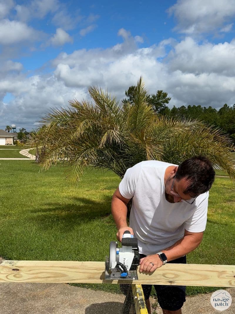 man cutting 4x4 post
