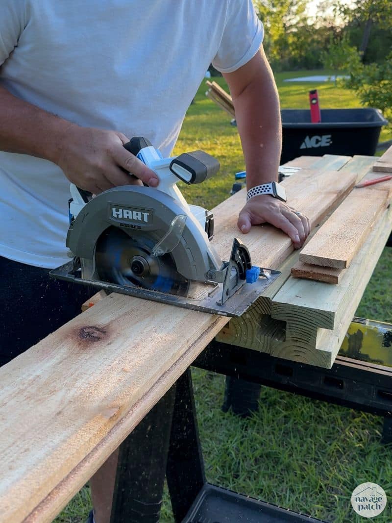 man cutting fence pickets