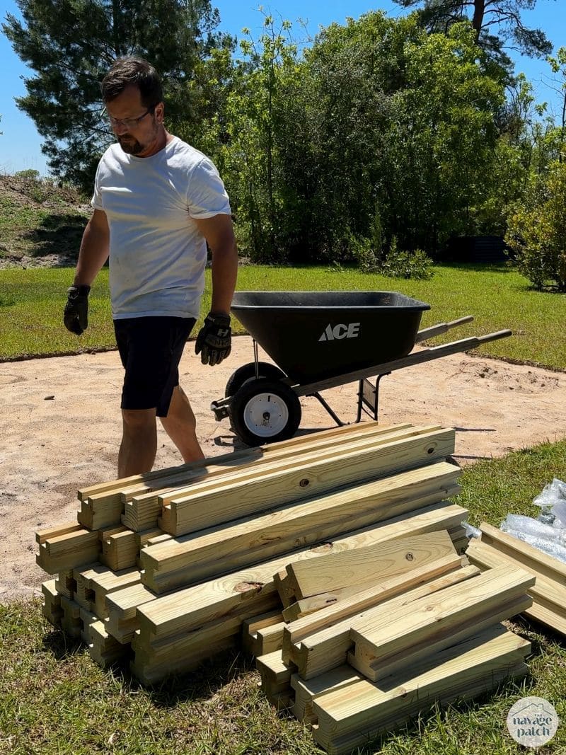 man unloading wood from a wheelbarrow