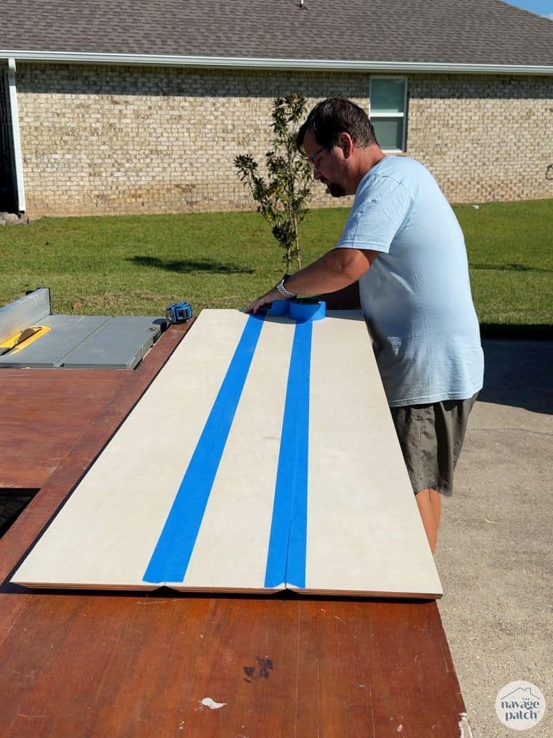 man taping pieces of plywood