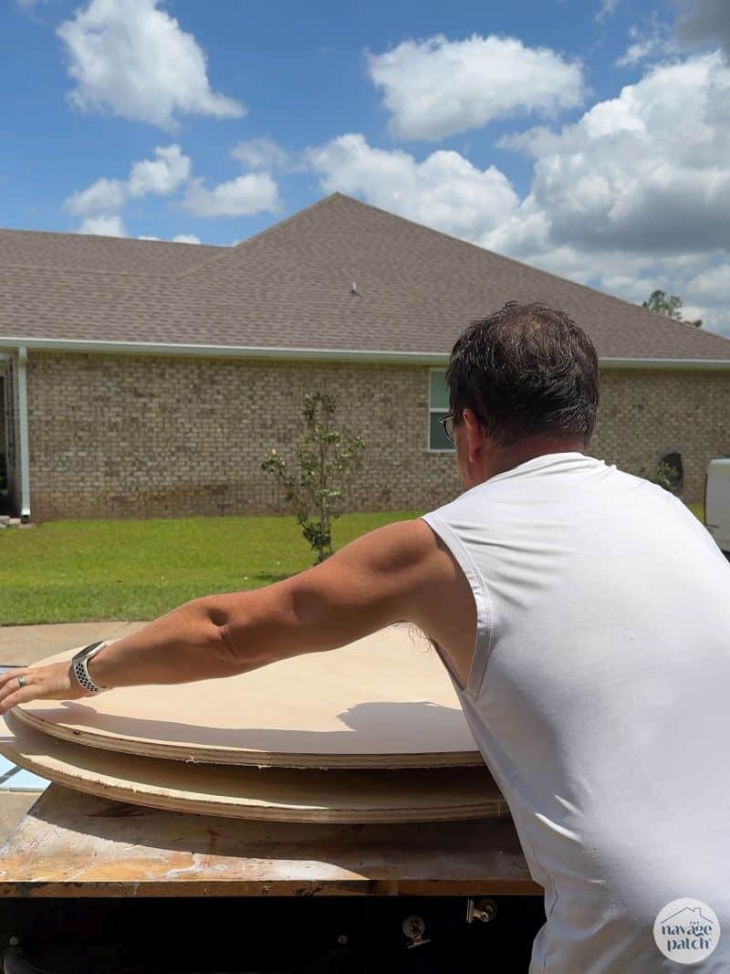 man gluing two plywood disks together