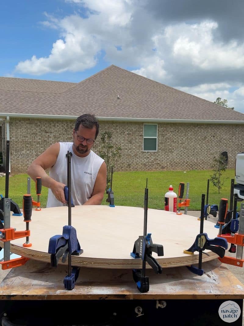 man gluing two plywood disks together