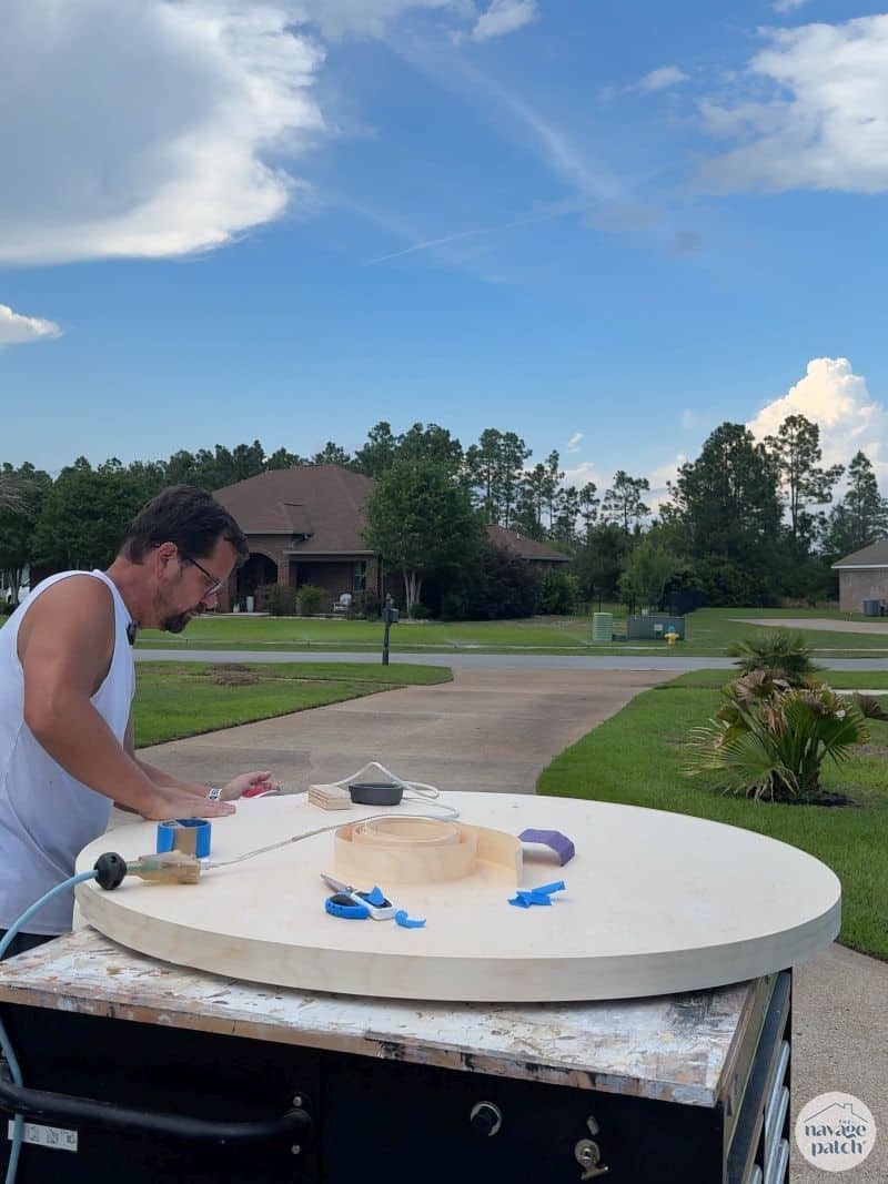 man putting edge banding on a table