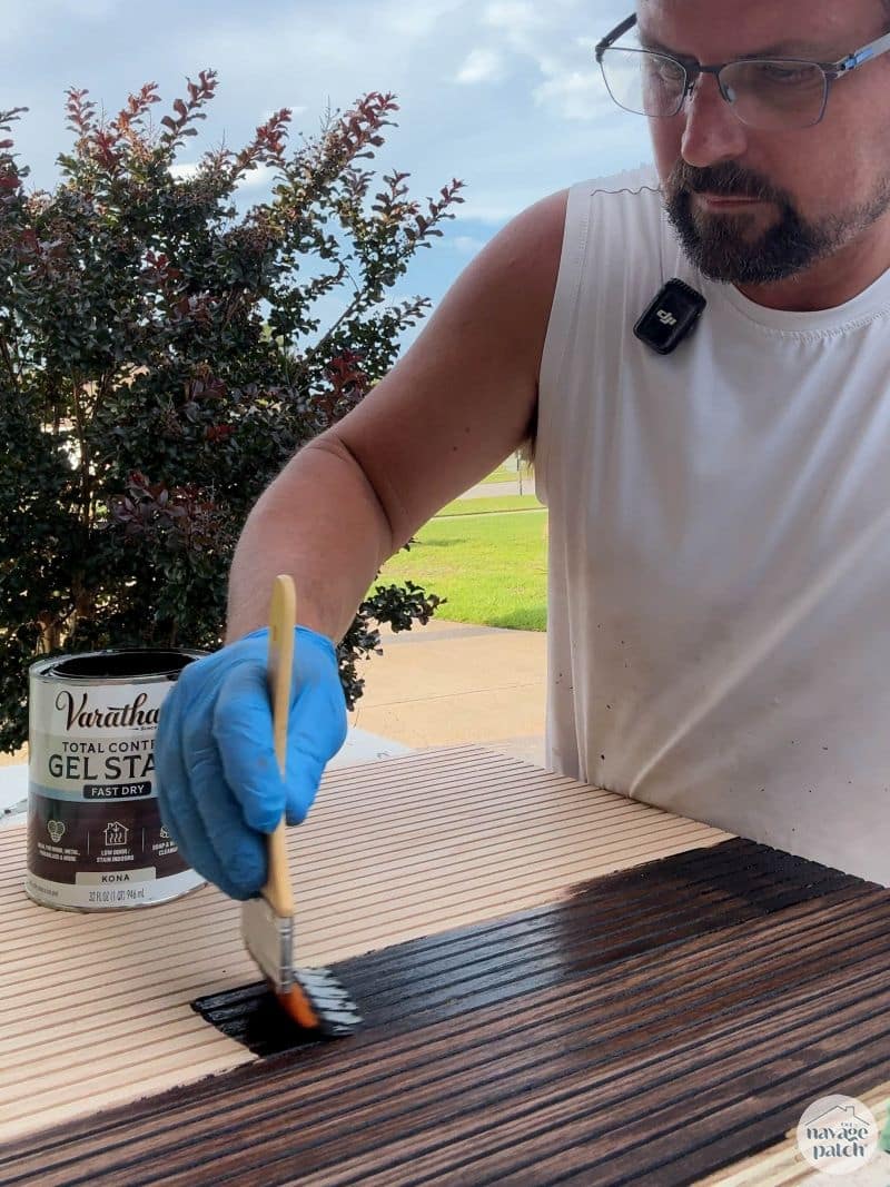 man staining a cabinet