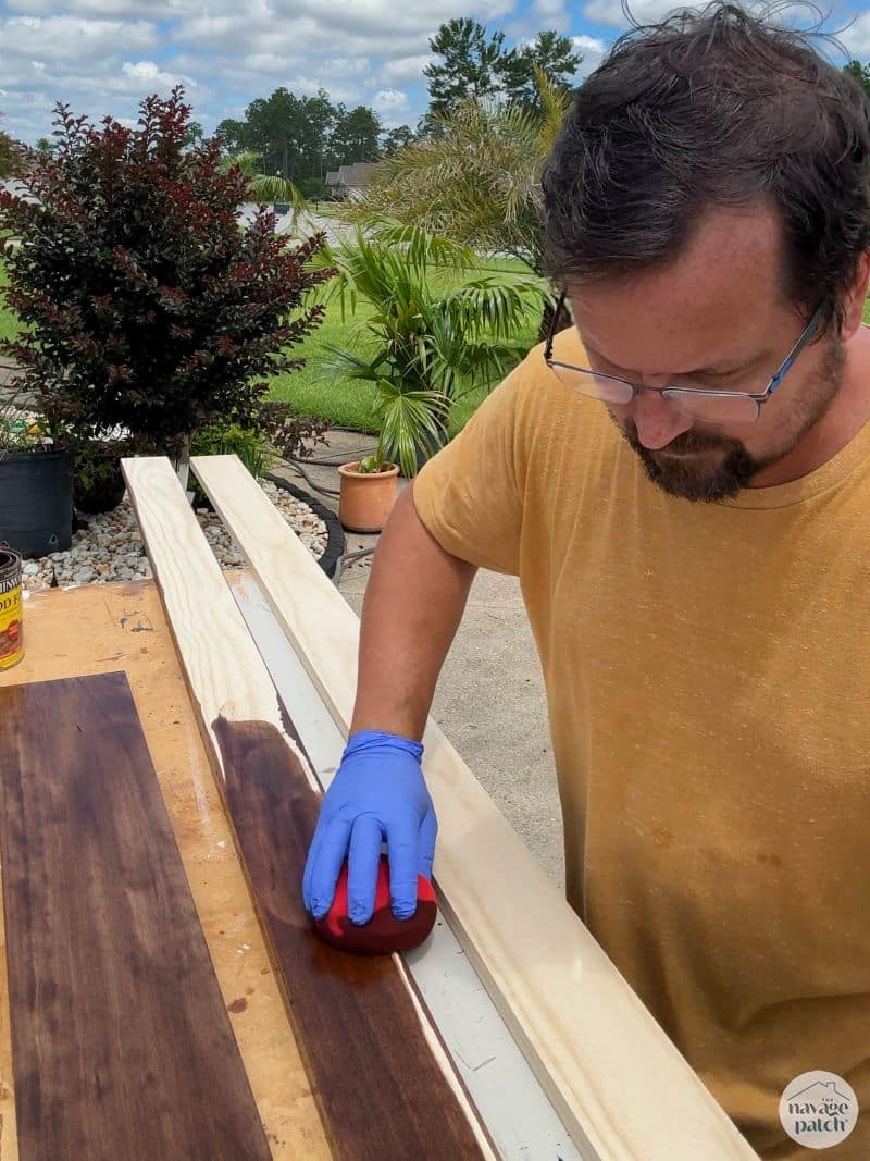 man staining pine boards