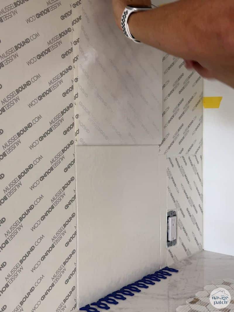man tiling wall