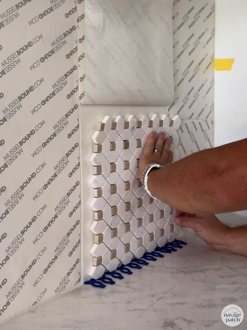 man tiling a wall