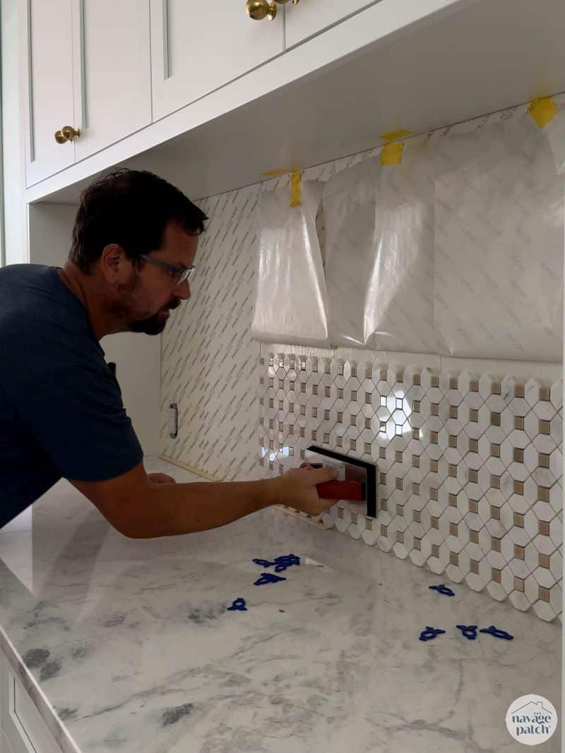 man tiling a wall