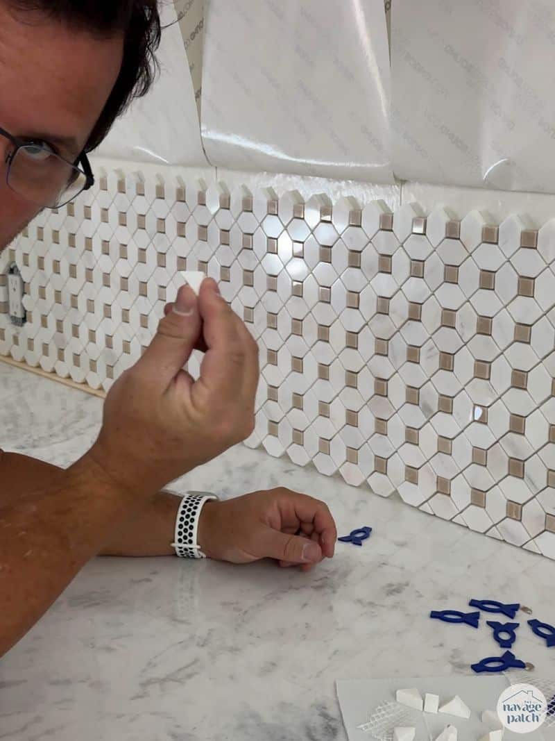man tiling a wall