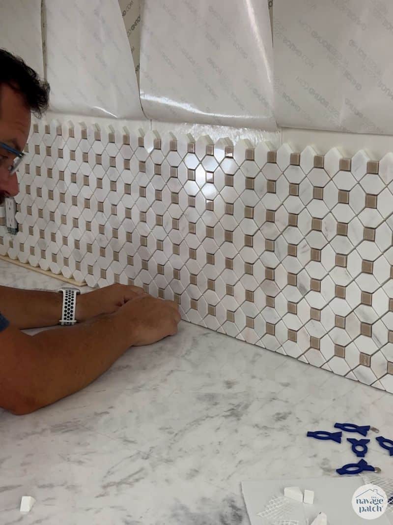man tiling a wall