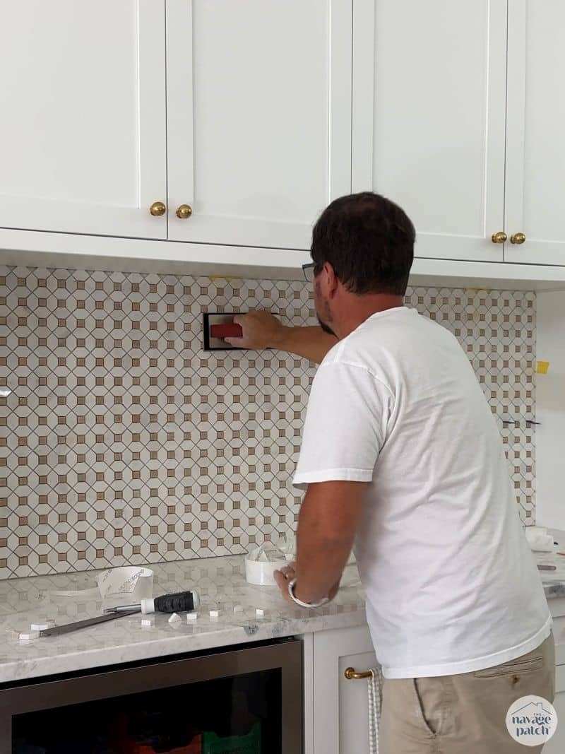 man tiling a wall