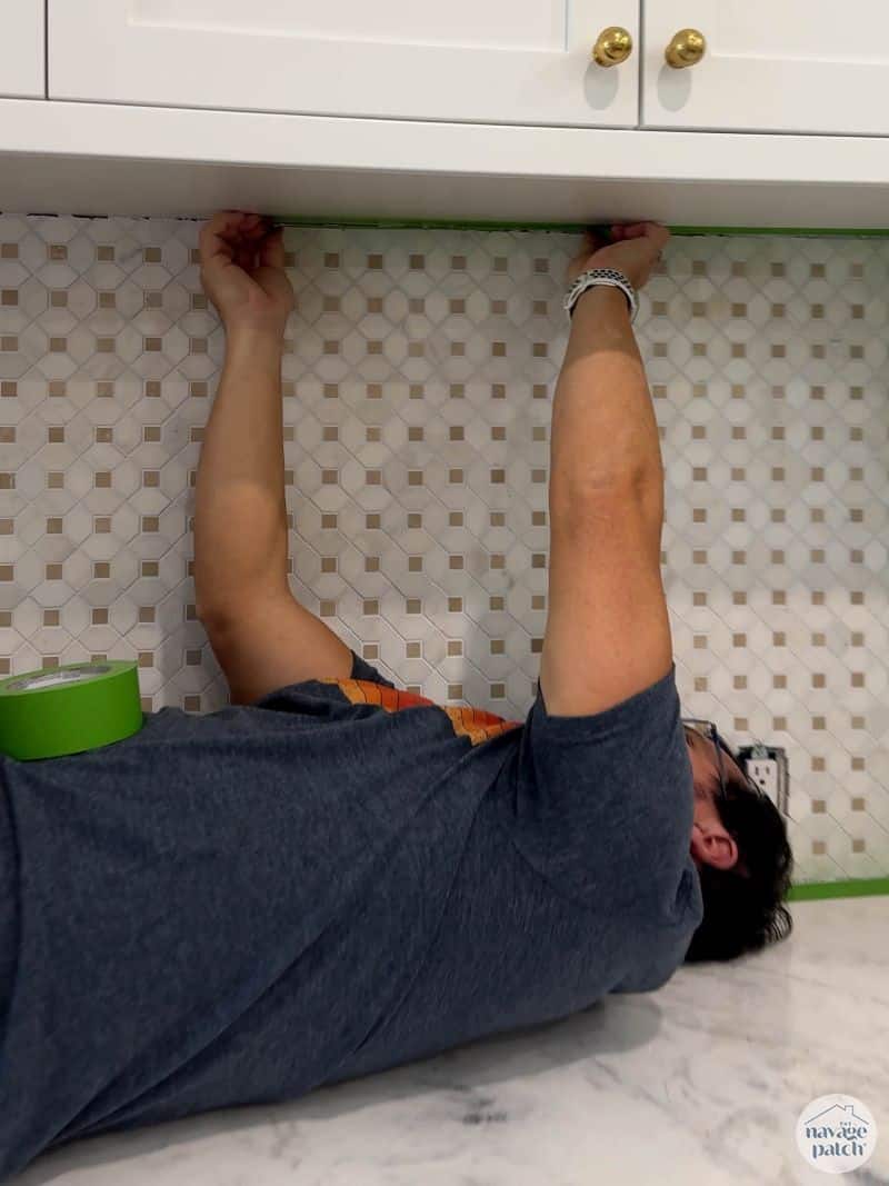 man taping tile for caulk