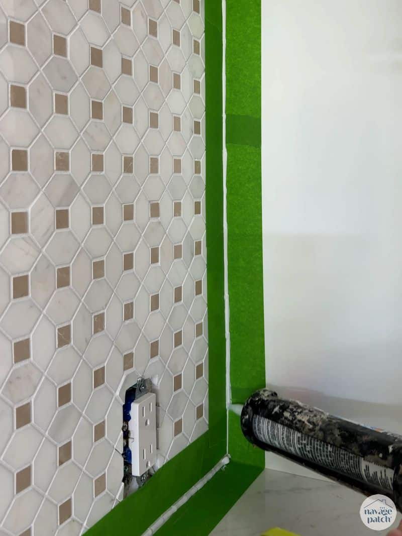 man caulking tile wall