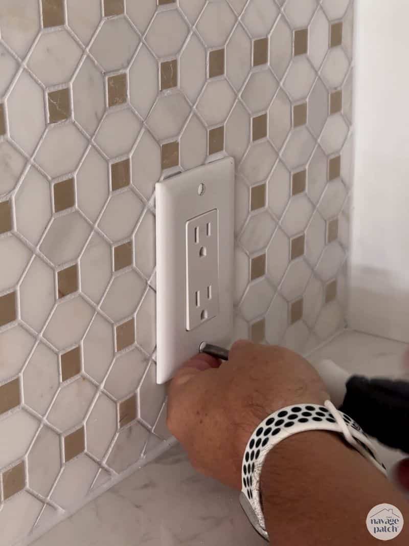 man putting a cover plate on a wall