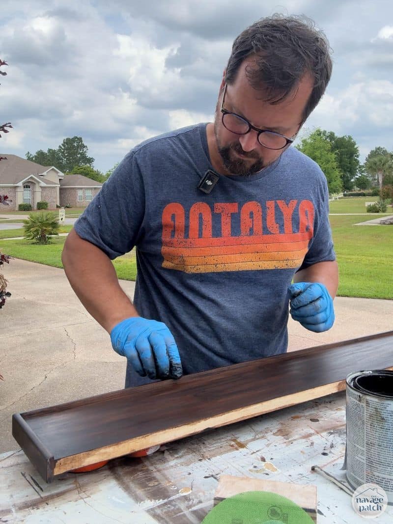 man staining a shelf