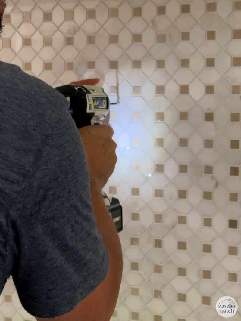 man drilling through tile