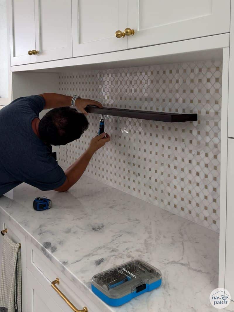 man hanging shelf