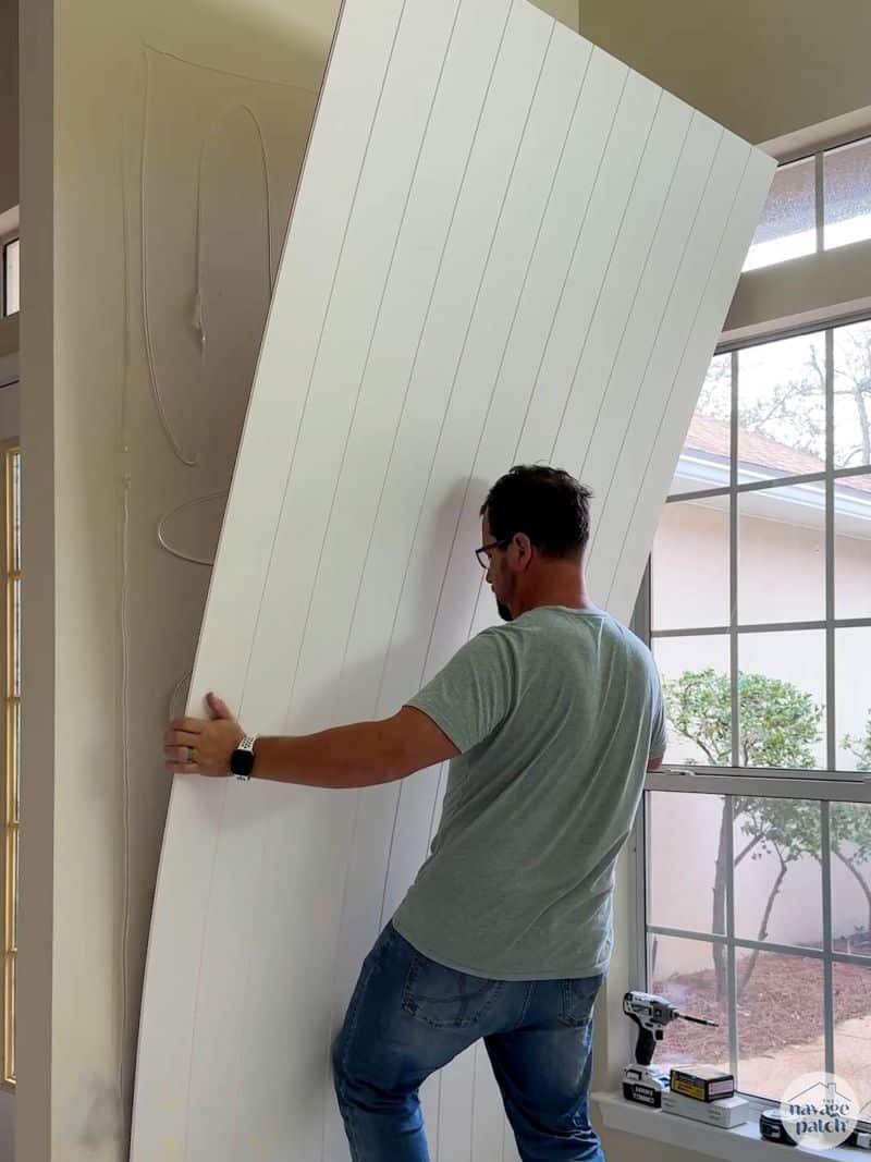 man attaching a panel to a wall