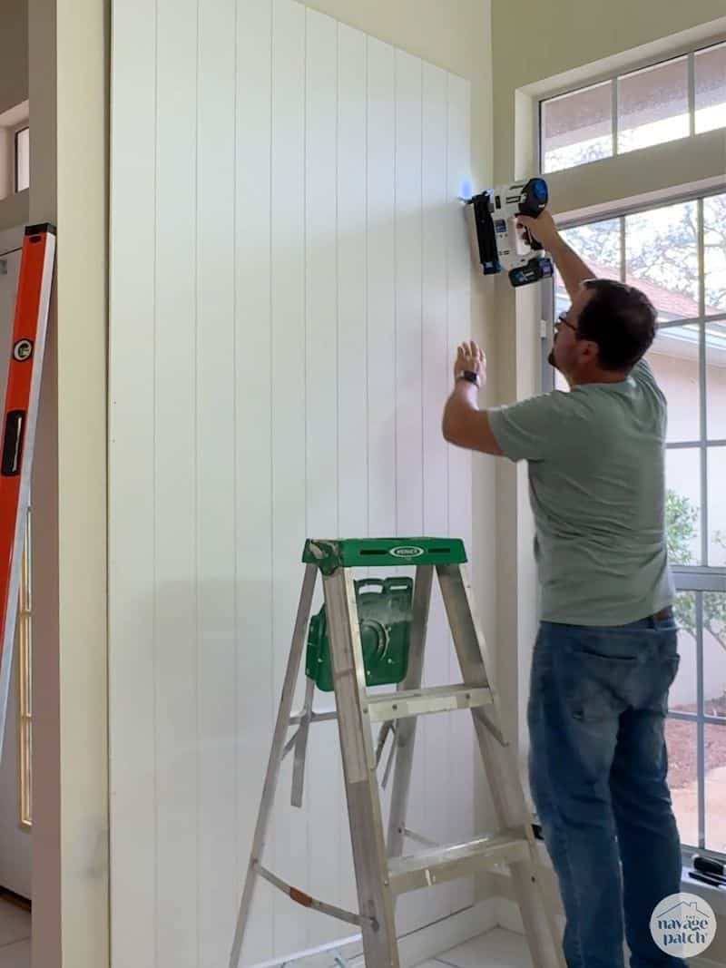 man nailing panel onto wall