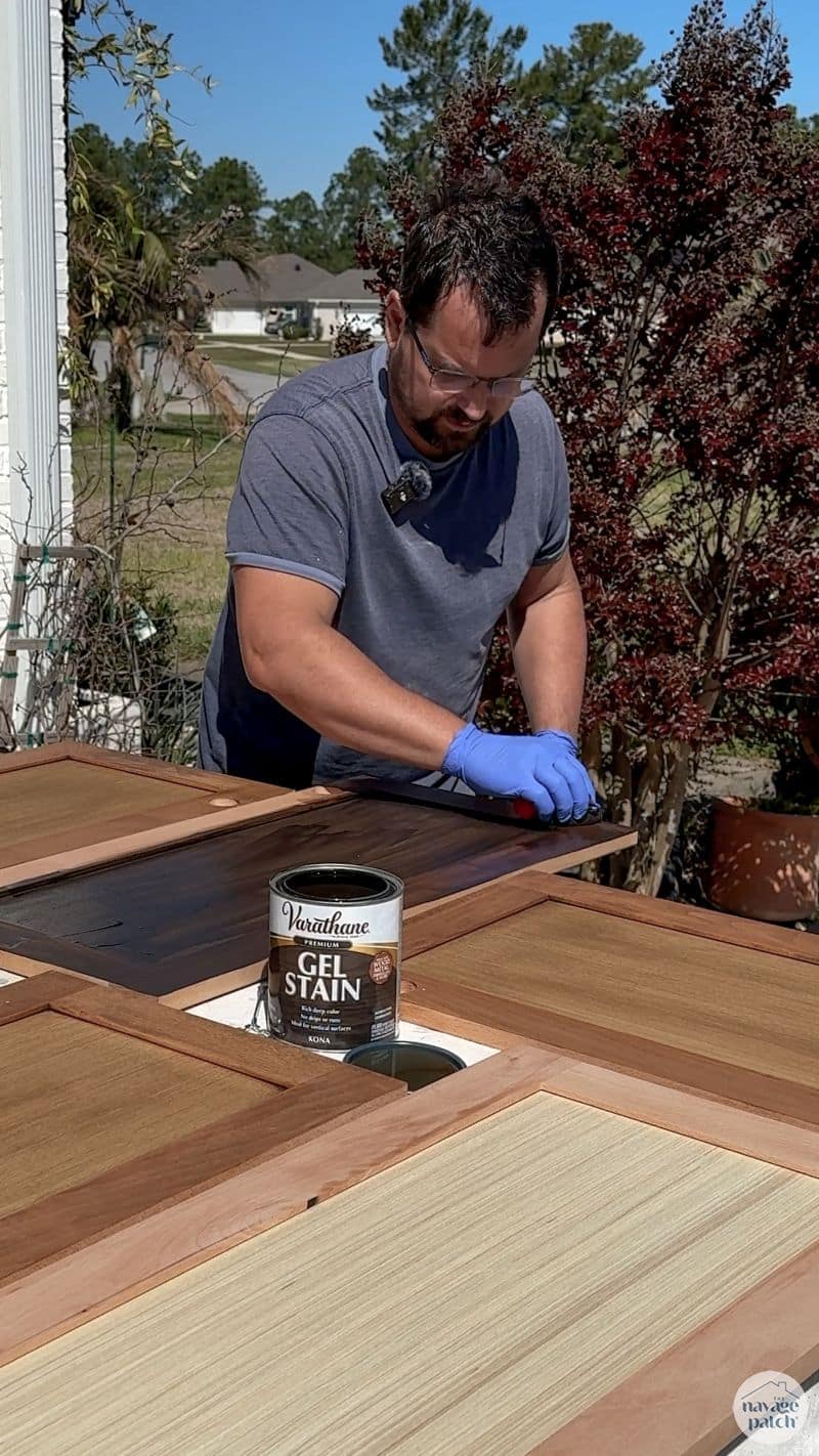 man staining cabinet doors