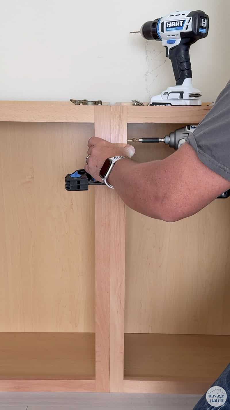man screwing cabinets together