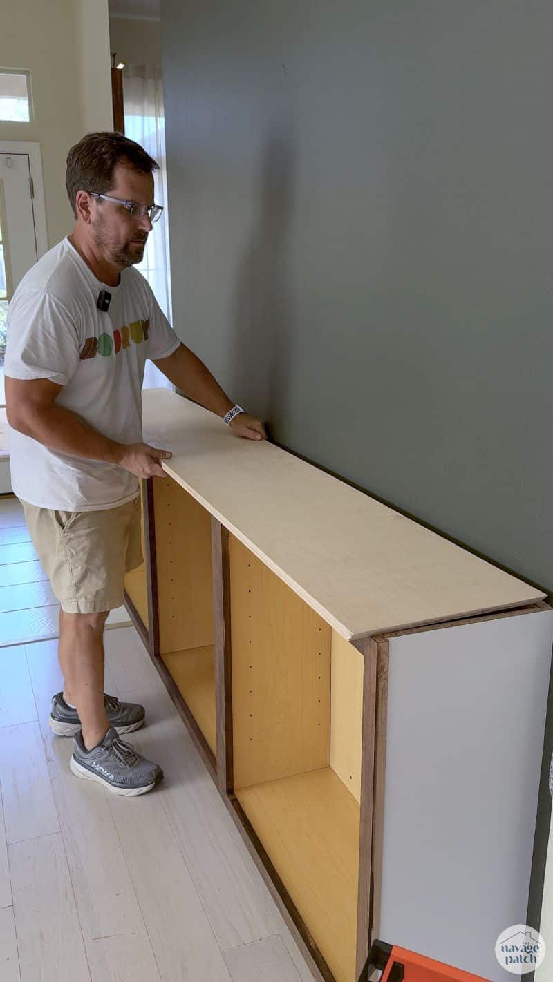 man putting a countertop on cabinets